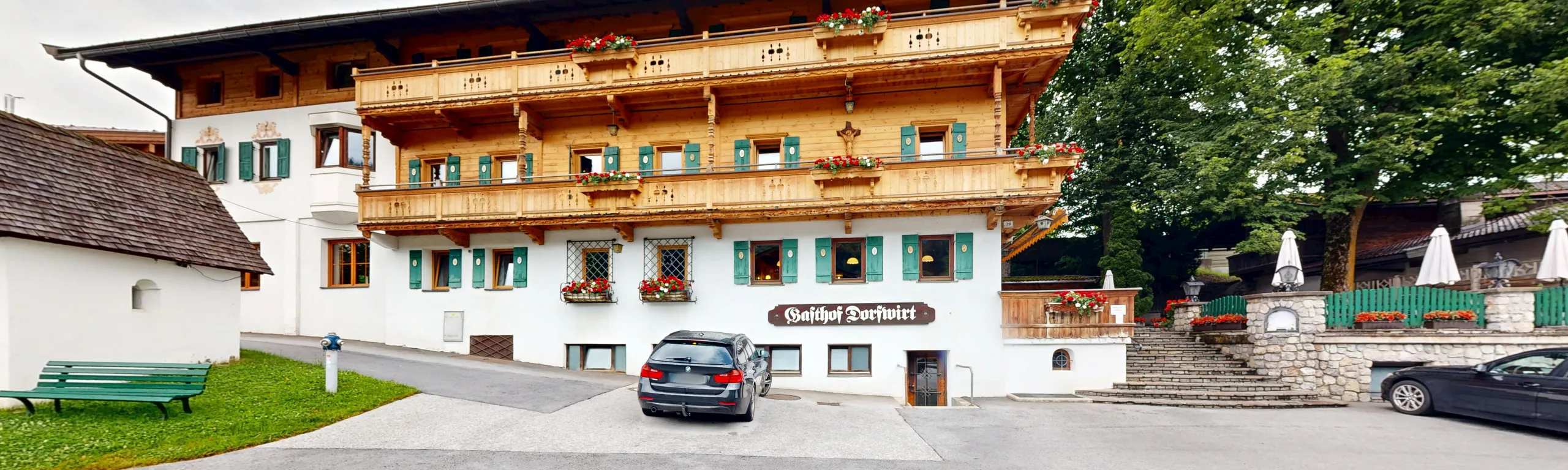 Traditionelles Gasthaus mit Balkon und Blumen in der Fassade.