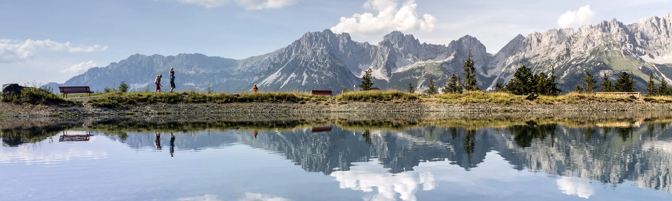 Blick auf den Astbergsee mit Bergen und Wanderern