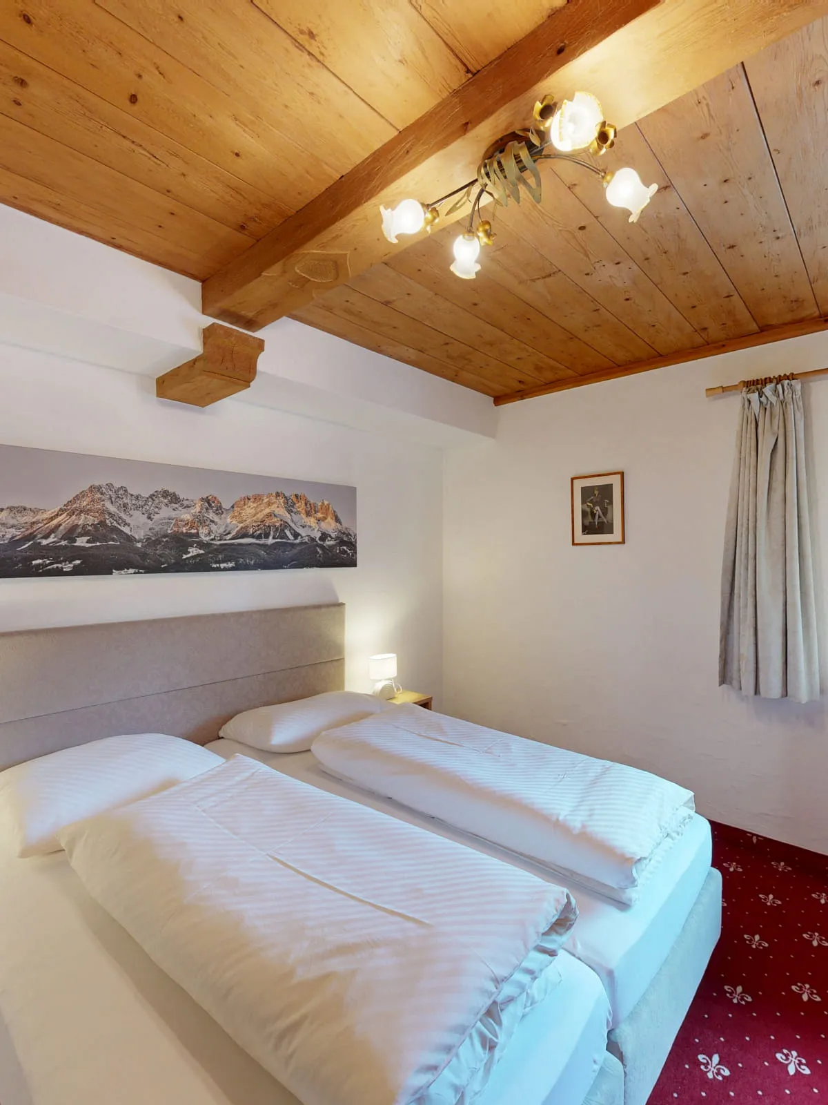 Zimmer mit zwei Betten und Fenster zur Berglandschaft