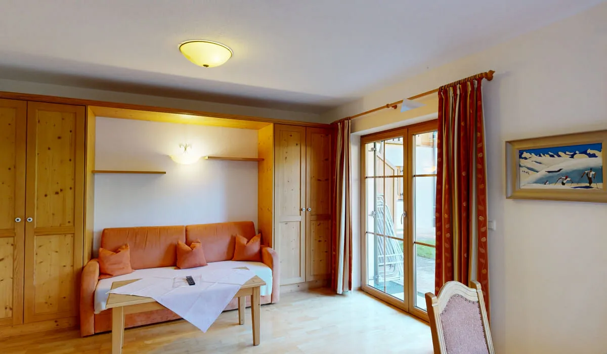 Gemütliches Wohnzimmer mit Sofa und Terrassentür
