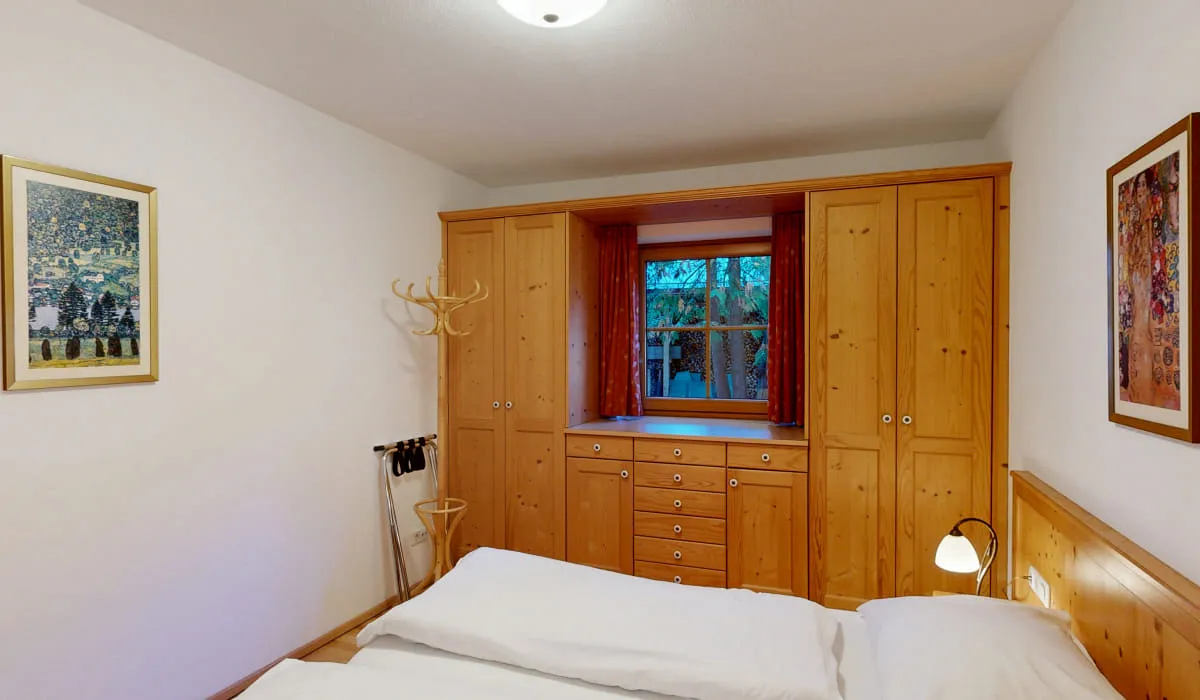 Holzschränke und Bett in einem hellen Schlafzimmer