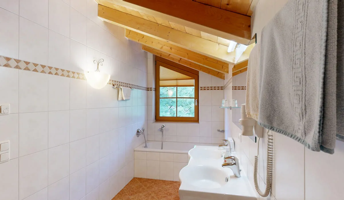 Helles Badezimmer mit Holzdach und Fenster