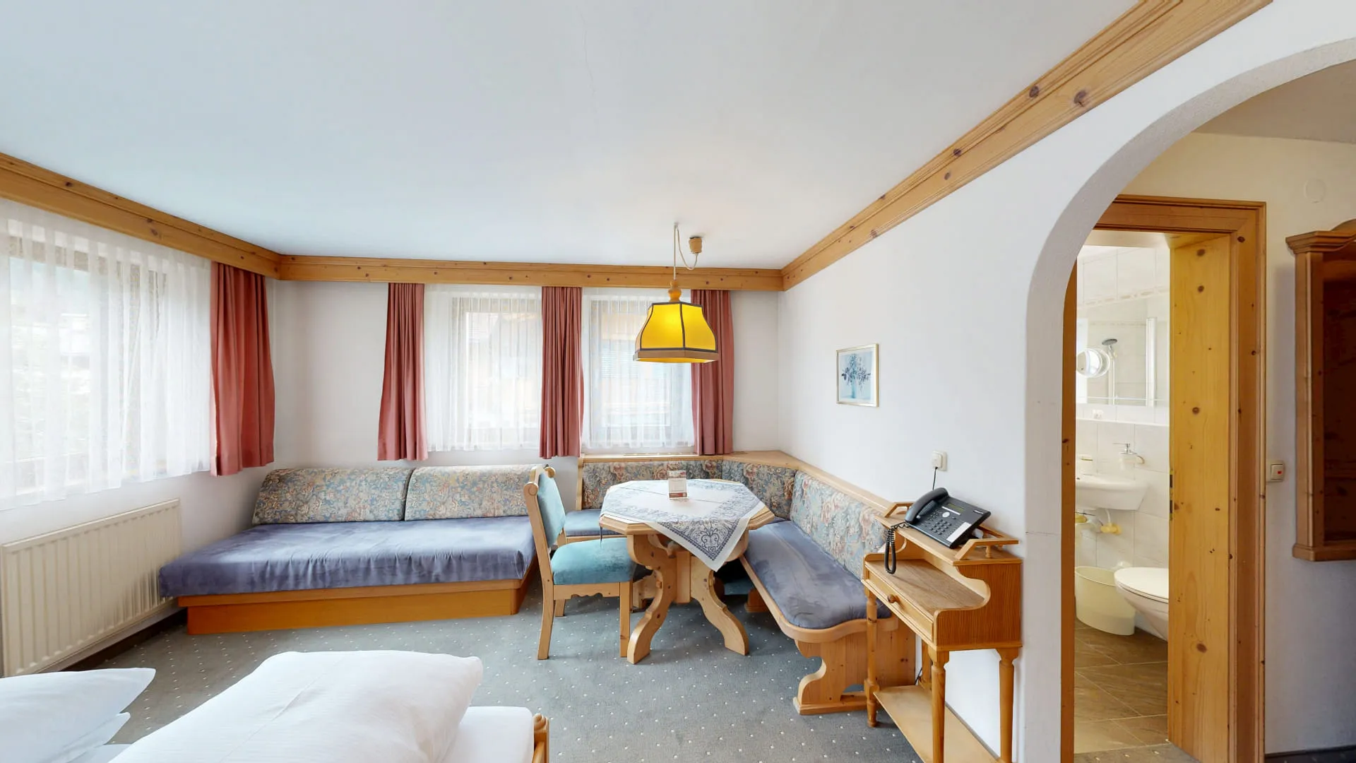 Gemütliches Zimmer mit Sofa, Tisch und Zugang zum Bad