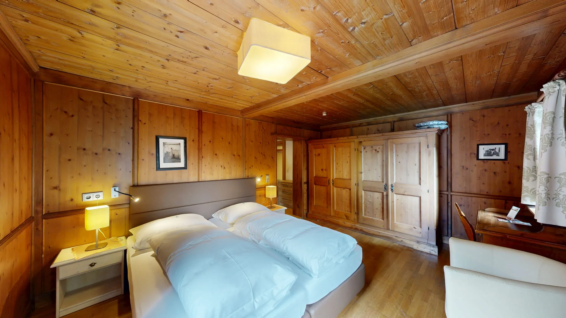 Holzverkleidetes Schlafzimmer mit zwei Betten und Schrank